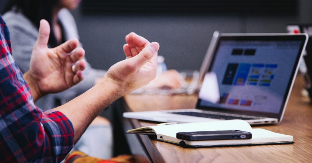 picture of a person gesturing near a computer
